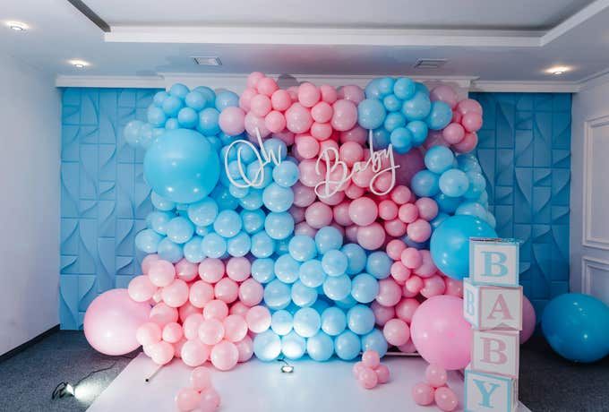 Dekorativ ballongvägg i rosa och blått för en gender reveal-fest.